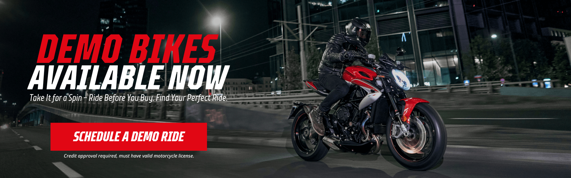 Rider on red demo sportbike in city with nighttime lighting